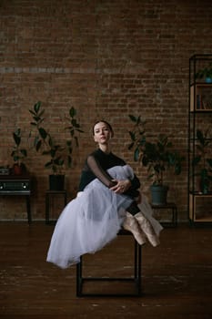 A ballerina gracefully stretches in a minimalist studio, embodying elegance and commitment to her craft