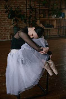 A ballerina gracefully stretches in a minimalist studio, embodying elegance and commitment to her craft