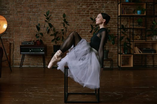 Elegant ballerina gracefully stretches in a minimalist studio, embodying elegance and commitment to her craft