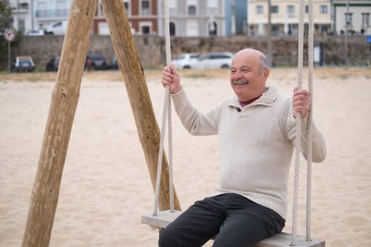 An hispanic elderly person swinging on a swing, reminiscing about childhood.