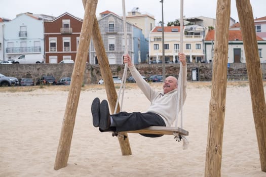 An hispanic elderly person swinging on a swing, reminiscing about childhood.