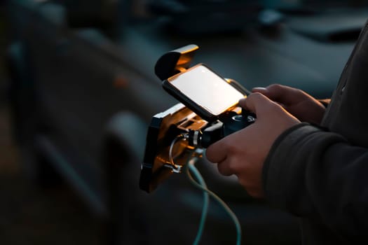 A man holds a remote control in his hands and controls a UAV flight, a drone or an aircraft with a powerful antenna, a man is involved in the development of technologies, does a security mission.