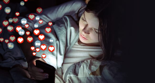 Young girl lies in bed at night with a mobile phone and sends or receives likes and hearts on social networks, a woman publishes news, the symbols of hearts and likes are added over image.