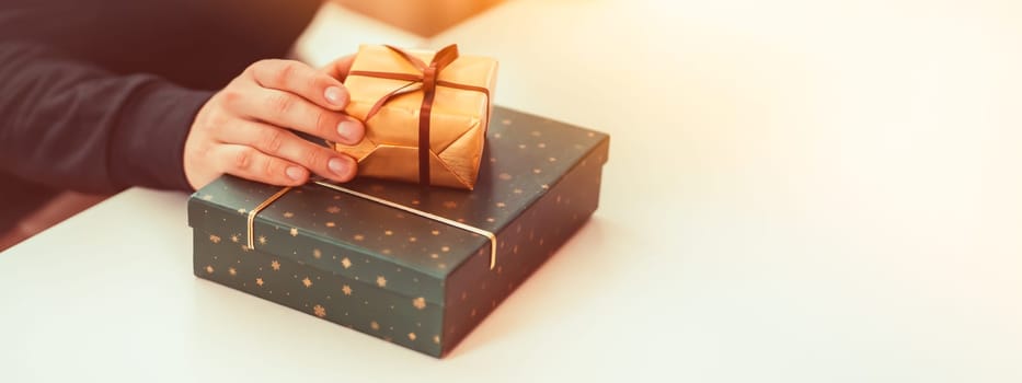 Male hands hold gifts in beautiful wrapping paper closeup view, a man prepares gifts for his loved one, relatives, friends and family for celebration the holiday.