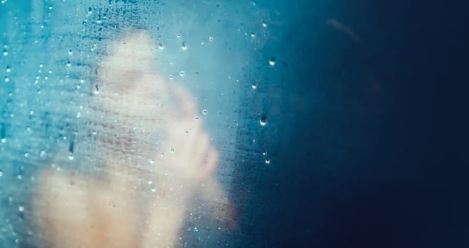 A young smiling girl takes a shower, washes with shampoo in a modern shower cabin, a woman relaxes, taking bath procedures, takes care of the beauty and health of her body.
