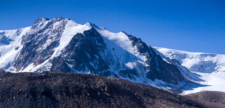 Rocks of the highlands, snow-capped peaks of mighty mountains, a stunning view of the glacier from above.