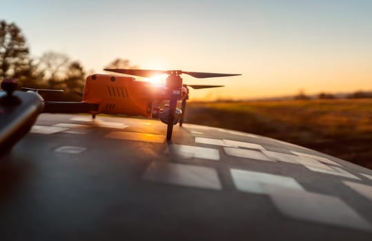 A drone and remote control against the sunset outdoors, in the rays of the sun. UAV technologies for monitoring territories, secret missions from the air, agricultural purposes and security.