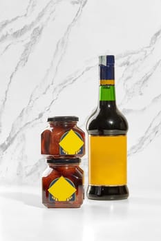Two baba preserving jars and a borsci s. Marzano elixir bottle are displayed on a white marble surface