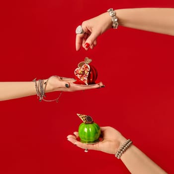 Women's hands presenting delicious heart-shaped desserts, showcasing culinary expertise and valentine's day treats