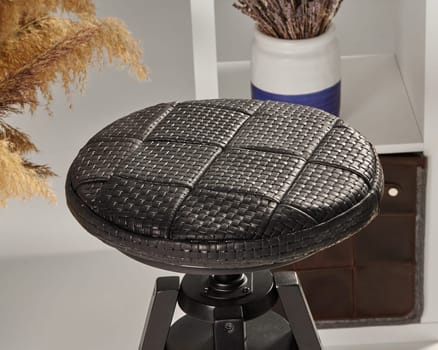 Close-up of a stylish round black leather stool seat pad with a woven pattern, adding a touch of elegance to modern home decor