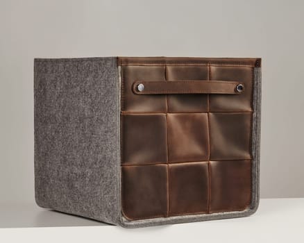 Elegant storage box combining leather and felt materials, featuring a convenient handle for easy portability