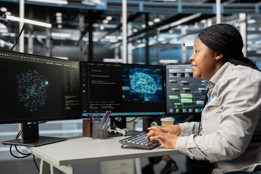 Data center system administrator using machine learning algorithms to analyze large datasets. African american server farm admin using artificial intelligence to recognize data patterns