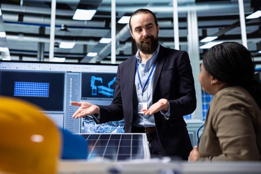 Photovoltaics factory businessmen discussing upgrades to make to improve sales. Solar panels manufacturing plant managers brainstorming ways to reduce downtime and increase production