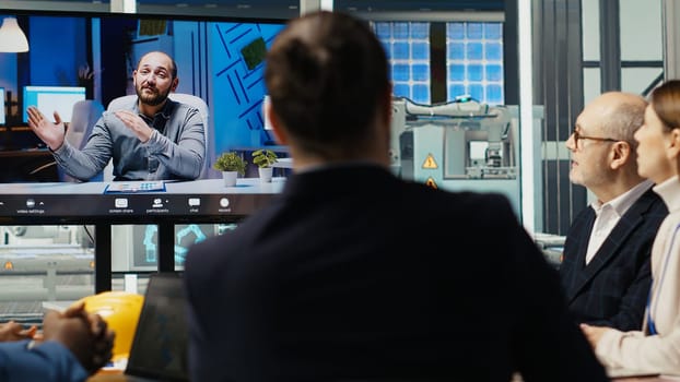 Experts optimize factory equipment energy output during remote teleconference call. Photovoltaics plant researchers doing internet videocall meeting, evaluating energy production, camera B