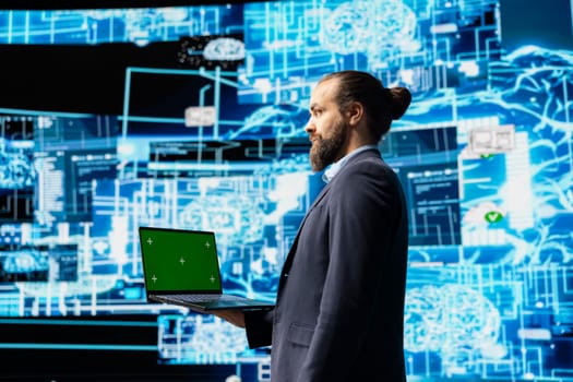 Business administrator uses mockup display next to AI neural networks system, practicing machine learning and cloud computing. Young man implementing artificial intelligence brain.