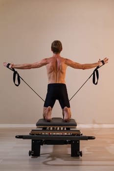 A man doing Pilates on a reformer