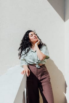 Portrait of a beautiful curly brunette woman in summer clothes