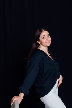 Portrait of a beautiful fashionable brunette woman in black and white business clothes