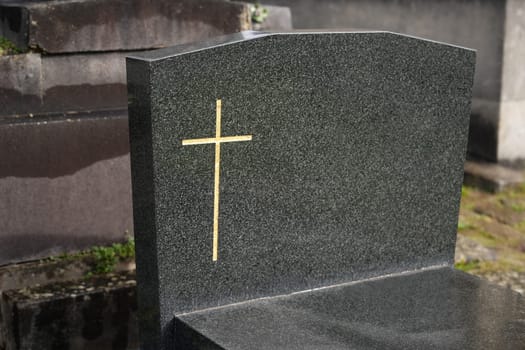 Cross on a marble slab on a grave in a cemetery