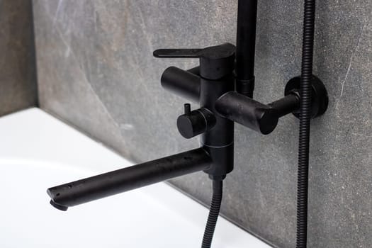 A sleek black faucet featuring a durable hose meticulously attached to it for added convenience and functionality in your kitchen or bathroom