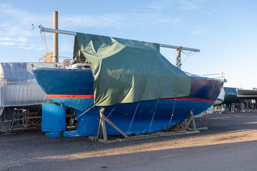 Sailboat covered and stored out of the water for the winter, winter storage for the sailboat in Finland, Suomenoja, winterizing , short season in Northern country, cold conditions