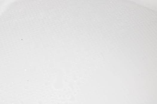 A closeup view of a predominantly white surface that is adorned with numerous small dots scattered across its entirety