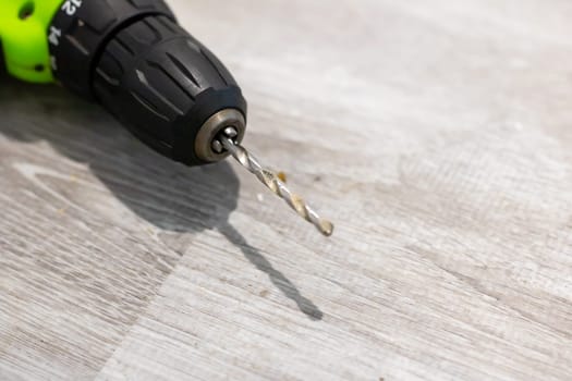 This is a closeup view of a drill bit resting on a wooden surface, showcasing its fine details and design intricacies