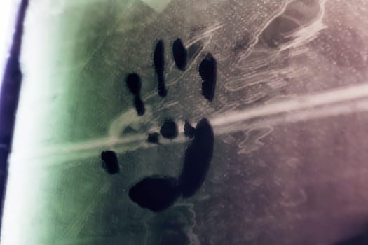 A distinctive hand print stands out prominently against an artistic backdrop featuring vibrant green and deep purple hues