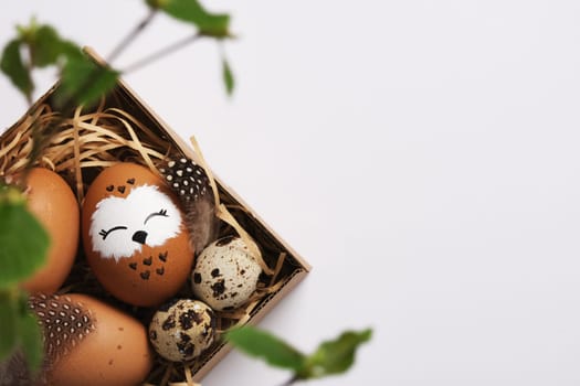 Hand painted owl egg in a nest with quail eggs. Space for your text.