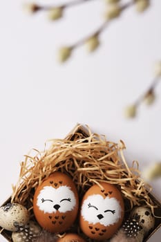 Hand painted owl egg in a nest with quail eggs. Space for your text.
