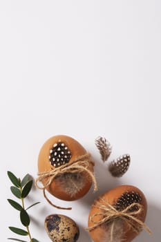 Easter eggs decorated with feathers and twine. Space for your text.