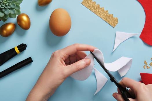 DIY Easter Egg King. Step-by-step instructions. Step 4. From white felt or fur, cut a semi-circular strip, the smaller part of it should match the smaller part of the red figure.