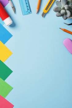 Supplies for paper art hobby: scissors, craft knife, pencil, eraser, colored paper. Space for your text. Paper crafts work table flatlay.
