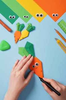 Making origami carrot. DIY project. Draw stripes on the orange part of the carrot.