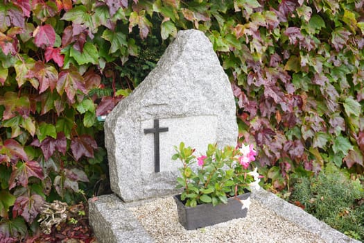 Cross on a marble slab on a grave in a cemetery