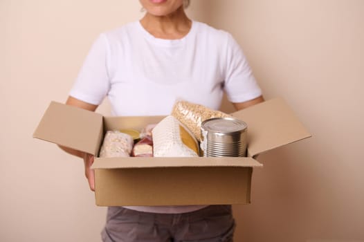 Community assistance represented in this image shows a carton with essential dry foods and canned goods for distribution. Highlights the importance of charitable efforts during emergencies.