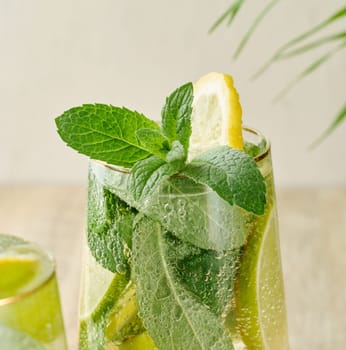 A sprig of mint in a glass of lemonade on a white background