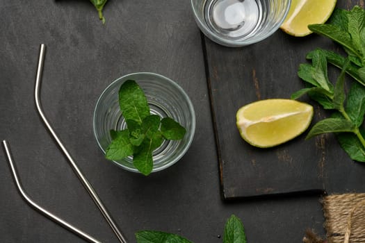 Bunch of fresh green mint, lime slices, glasses, top view. Cocktail ingredient