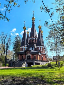 Yukki, Leningrad Oblast, Russia - May 28, 2025. Church of St. John the Baptist in Yukki showcases its striking architecture with golden domes under a blue sky.