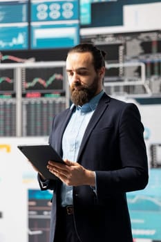 Modern businessman uses digital graphs and analytics to improve finance models for fruitful management decisions. Optimizing performance with tech intelligence and insightfulness.