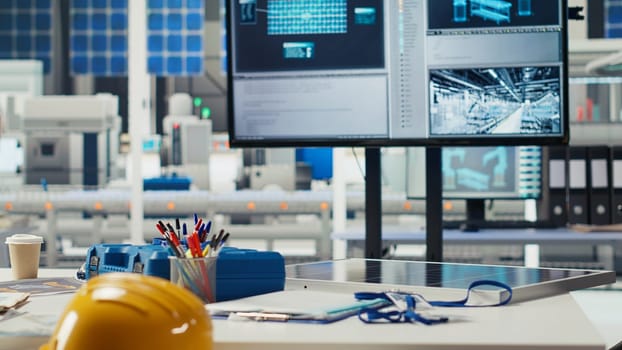 Research and development photovoltaics factory office used to oversee performance of robot arms placing solar panels on assembly lines. Panning shot of empty facility floor with solar plant machinery