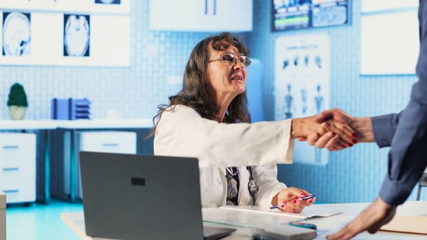 Senior physician consulting an old male patient and gives advice, analyzing the diagnostic report to provide the correct treatment. Utilizing medical technology for care management. Camera A.