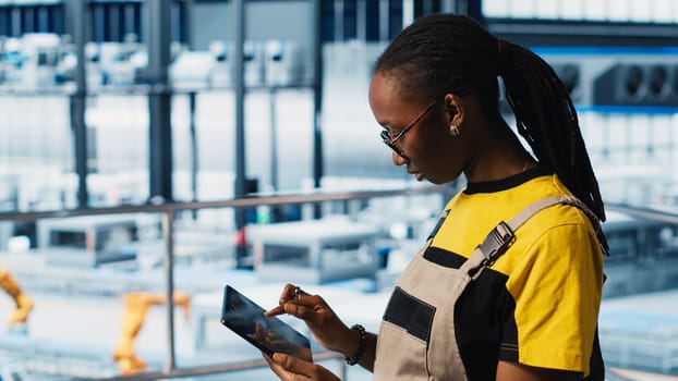 Smart factory engineer implements automated workflows using artificial intelligence tech, computerizing manual operations. Woman integrates sensors into production using AI technology, camera A
