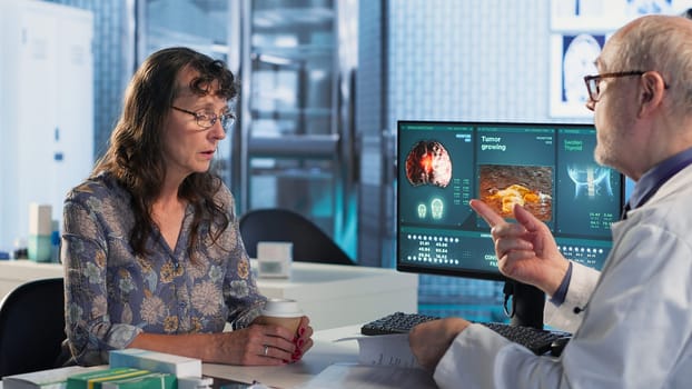 Physician and patient discuss an x ray and MRI scan focusing on preventive medicine and cancer awareness strategies. Educating a woman on chemotherapy options and preventative care. Camera B.