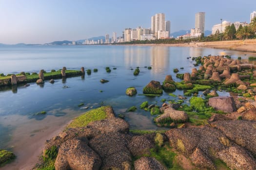 Panoramic view of seaside embankment and green moss beach in Nha Trang city with skyscrapers in Vietnam