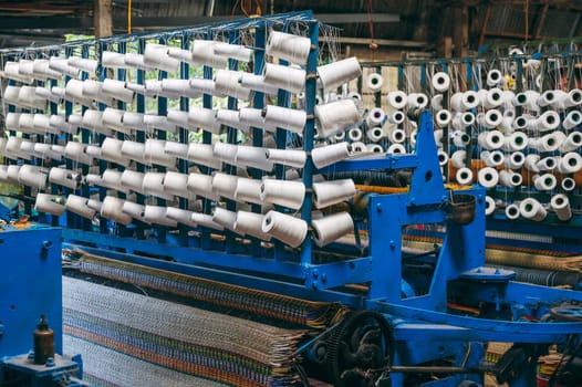 Vietnamese workshop with looms weaving machines for production of traditional woven reed mats in Vietnam in Asia