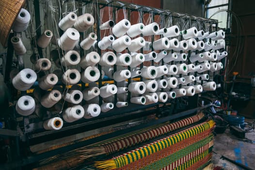 loom weaving machine in workshop at factory for the production of traditional woven reed mats in Vietnam in Asia