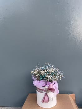 Vase with bouquet of flowers for a gift on a gray background