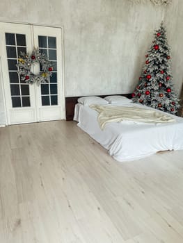 Bed in the bedroom with a Christmas tree and gifts for the new year