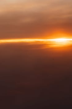 Beautiful landscape on the sunset sky with clouds from the airplane window